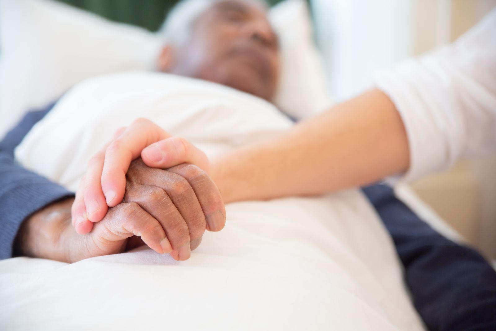 A family member holding an older person's hand